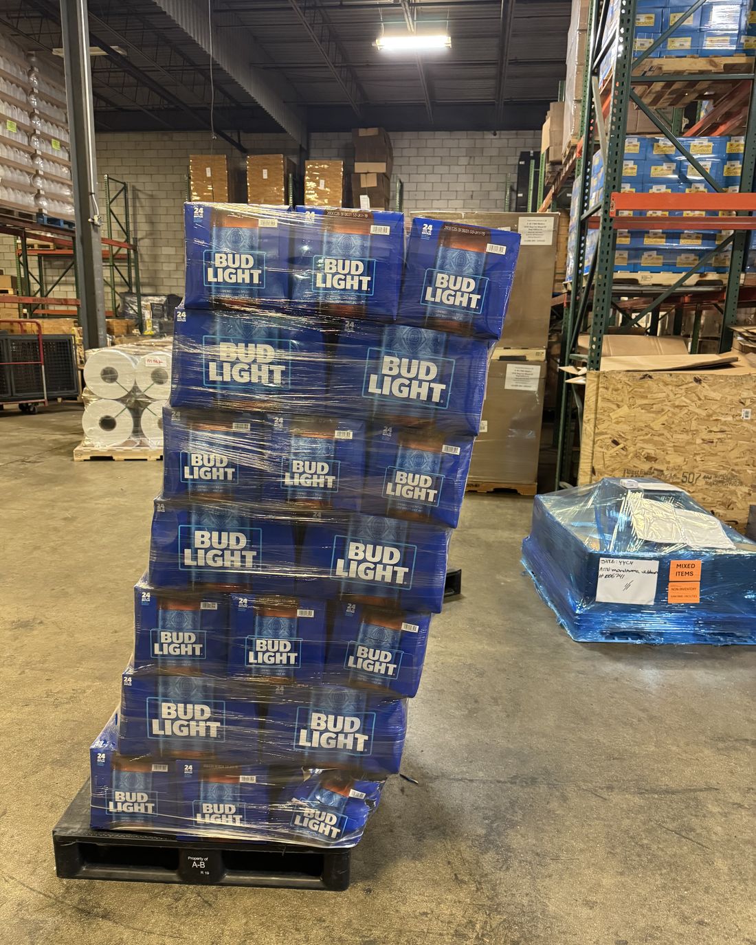 A pallet of beer cases leaning badly to one side, cases stepped out of line and the wrap sagging