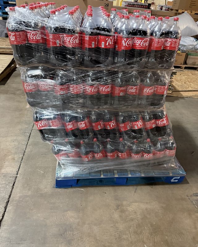A pallet of bottled drinks wrapped and staged on the dock floor