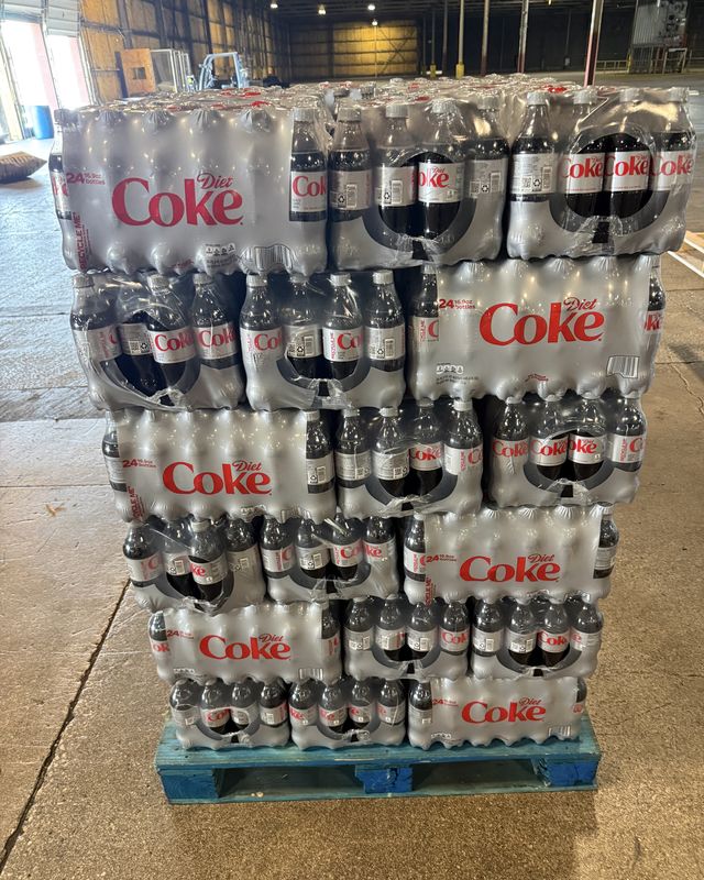 A tightly wrapped pallet of canned and bottled drinks on a blue pallet